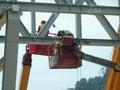 Construction workers using the mobile crane bucket Royalty Free Stock Photo