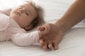 Serene adorable sleepy baby catching dads thumb, holding finger Royalty Free Stock Photo