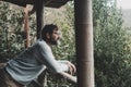 Serene adult man looking the nature outside home in terrace patio having relax and connection with nature. One house owner living Royalty Free Stock Photo