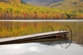 Serene autumn fall foliage reflection on lake with dock Royalty Free Stock Photo