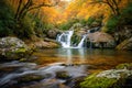 Serene autumn waterfall cascading through vibrant fall foliage and moss-covered rocks in a tranquil forest setting Royalty Free Stock Photo
