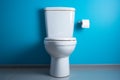 Serene bathroom setting features a white ceramic toilet set against a calming blue wall Royalty Free Stock Photo