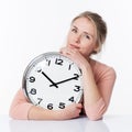 Serene beautiful young blond woman embracing a clock