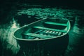 The serene beauty of an old wooden fishing boat floating empty in a river, surrounded by lush grassy shores and water lilies on a Royalty Free Stock Photo