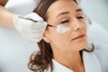 Beautician applying a nutrient mask to the patient face