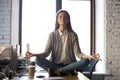 Serene calm business woman sit on office desk meditating Royalty Free Stock Photo