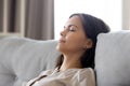 Serene calm woman relaxing leaning on comfortable couch having nap Royalty Free Stock Photo