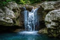 A serene and captivating scene showcasing a small waterfall beautifully nestled within a cluster of rocks, A gentle waterfall Royalty Free Stock Photo