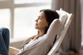 Relaxed young woman resting on comfortable rocking chair