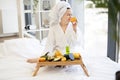 Woman holding orange near bed tray with beauty products Royalty Free Stock Photo