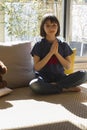 Serene child enjoying namaste while practicing mindful yoga at home