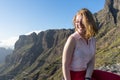 Serene Cute Tourist woman, laughing and admiring the freedom and the landscape in the mountain, sitting in a rock. Model sit and Royalty Free Stock Photo