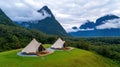 Serene elevated campsite with tents surrounded by mountains and clouds Royalty Free Stock Photo