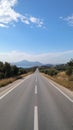 Serene Empty Road Stretching Into Horizon Under Blue Sky Royalty Free Stock Photo