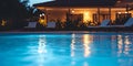 Tranquil evening poolside scene with warm lighting and relaxing chairs Royalty Free Stock Photo