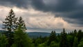Dark Clouds Over Green Forest With Tall Pine Trees Royalty Free Stock Photo