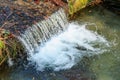 Serene forest stream cascade with moss-covered rocks and bubbling water Royalty Free Stock Photo
