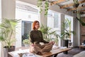 Calm young business woman doing yoga breathing exercise meditating at work. Royalty Free Stock Photo