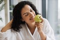 Serene healthy female after bath taking pleasure of fresh apple fruit aroma Royalty Free Stock Photo