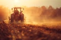 Tractor plowing field at golden hour