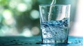 Close-up of water being poured into a clear glass against blurred background Royalty Free Stock Photo