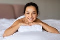 Serene lady lies on bed smiling at luxury spa interior Royalty Free Stock Photo