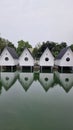 A serene lake reflects a row of charming white houses, creating a picturesque scene of tranquility and beauty Royalty Free Stock Photo