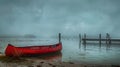 Serene lake view with red canoe on a misty day. quiet and peaceful scenery. simple and elegant outdoor style. nature Royalty Free Stock Photo