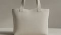A serene minimal presentation of a pale neutral light tote bag with soft warm white texture displayed in gentle ambient Royalty Free Stock Photo