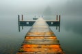Serene Misty Lake Scene with Wooden Pier Extending into the Calm Waters on a Foggy Morning Royalty Free Stock Photo