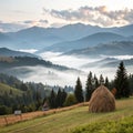 Misty mountain landscape with fog and haystack Royalty Free Stock Photo