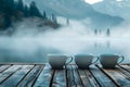 Serene Morning by the Lake with Three Cups on Wooden Pier, Misty Mountains and Tranquil Water Backdrop, Peaceful Nature Scene Royalty Free Stock Photo