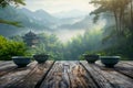 Serene Mountain Landscape with Misty Fog and Traditional Asian Pavilion Viewed from Wooden Table with Ceramic Bowls