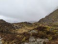 A scenic wilderness landscape with a cloudy sky over mountains and rocks Royalty Free Stock Photo