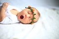 Serene newborn baby on a bed yawning