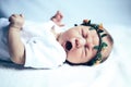 Serene newborn baby on a bed yawning