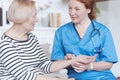 Serene nurse checking heartbeat and pulse of elderly patient Royalty Free Stock Photo