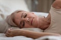 Serene older woman sleeping on comfortable pillow in bedroom. Royalty Free Stock Photo