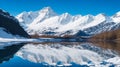 A serene pond reflecting a snow-capped mountain and a clear blue sky
