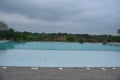 Serene Retreat with Pool and Tree Amidst Blue Skies and Clouds