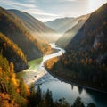 A serene river meanders through a valley between forested mountains ablaze with Royalty Free Stock Photo