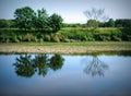 Serene River Ribble in Preston, showcasing tree reflections on a calm, sunny day Royalty Free Stock Photo