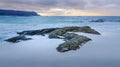 A rocky beach with waves crashing on it