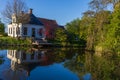 Serene rural house by a canal in the Netherlands. Spring greenery and the reflection of the white facade in the blue water create Royalty Free Stock Photo