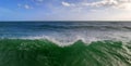 Serene sea panorama with big green wave in the foreground, tsunami