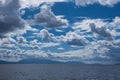 Serene seascape with clouds and mountains. Royalty Free Stock Photo