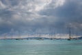 A serene seascape in Mallorca with multiple sailboats, peacefully anchored on calm turquoise waters
