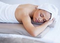 Serene at the spa. an attractive young woman lying on her stomach at a spa. Royalty Free Stock Photo