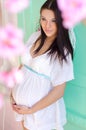 serene spring pregnant in a white dress on a turquoise backgrou Royalty Free Stock Photo