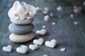 Serene Stacked Stones with White Orchids and Heart-Shaped Stones on Textured Surface Royalty Free Stock Photo